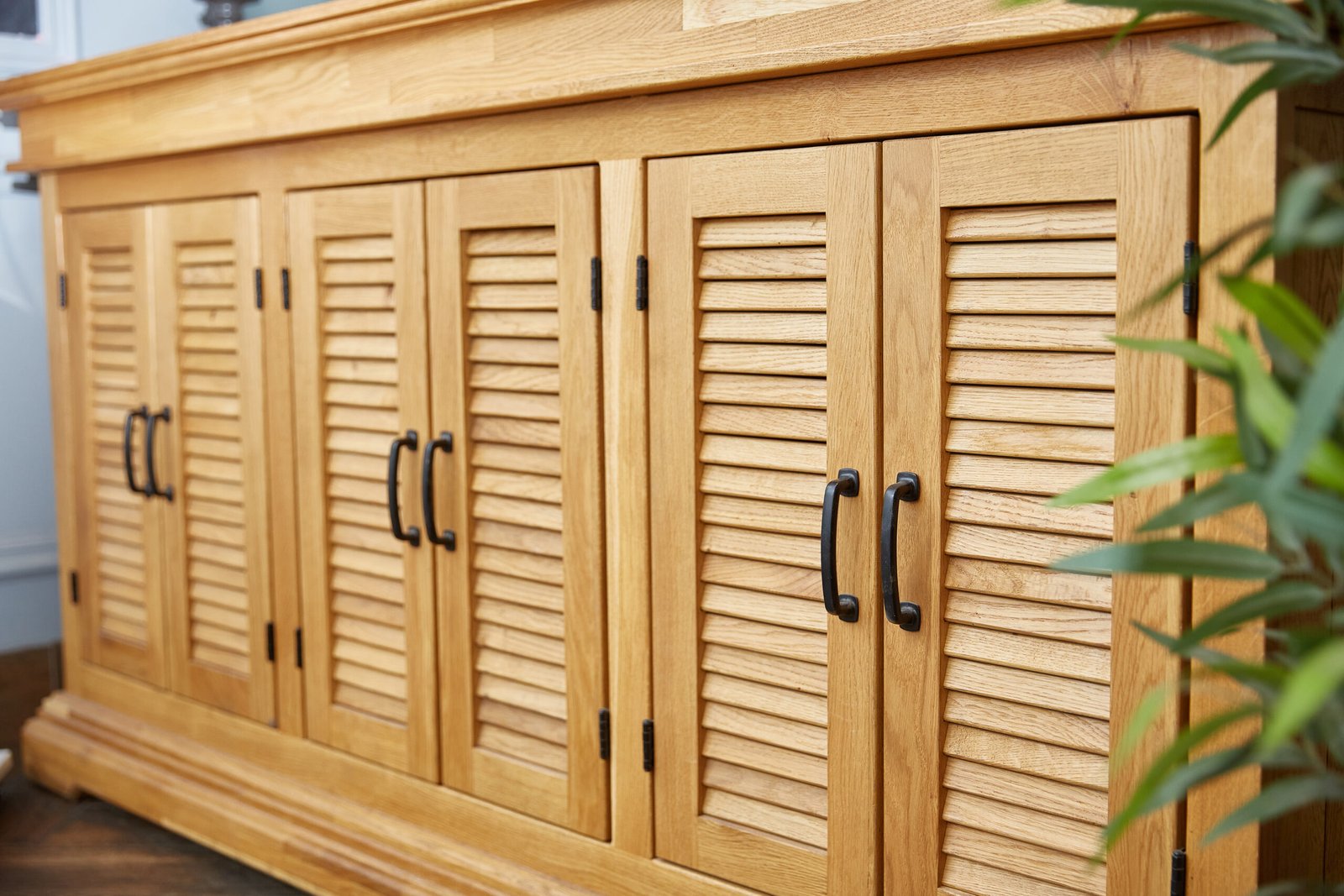 Large wooden dresser of drawers made of acacia wood. Close-up. Doors with blinds.