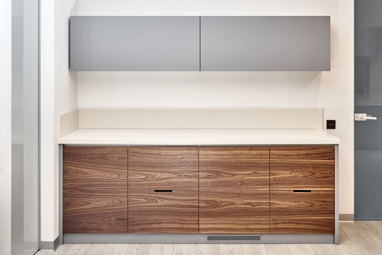 Contemporary kitchen furniture set in minimalist style of walnut wood and gray color with acrylic solid surface countertop in office